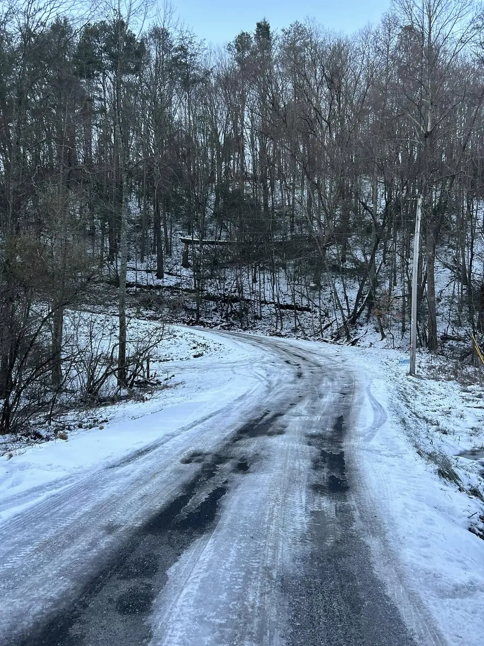 Icy back road curving through a snowy hillside in Gilmer County