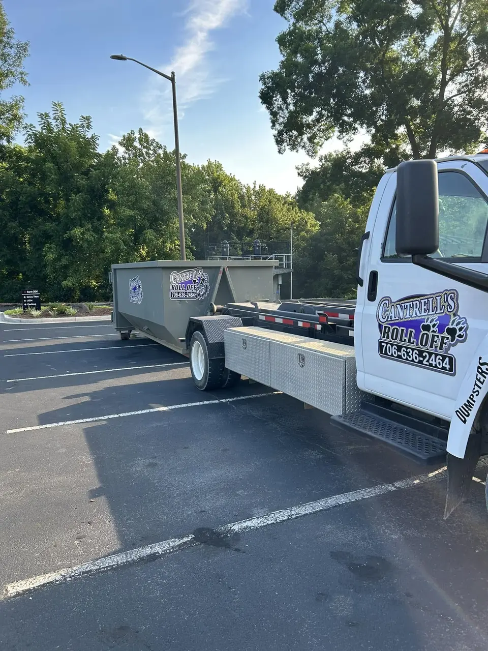 Cantrell's roll-off truck with a dumpster in a parking lot